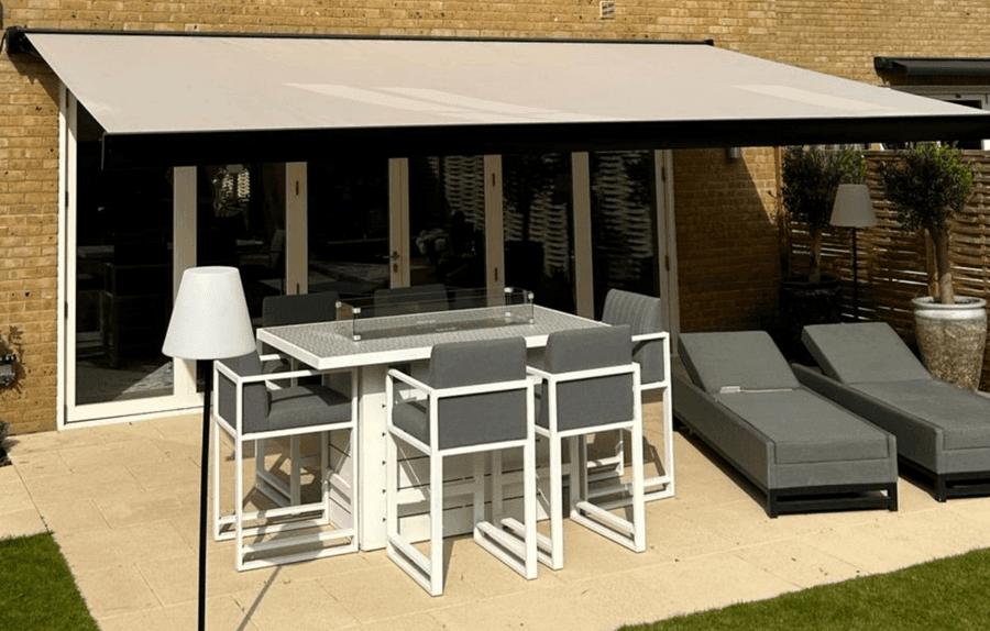Armony Plus fully cassetted awning in a residential setting, wide span awning covering a set of garden furniture including a table and chairs and two sun loungers