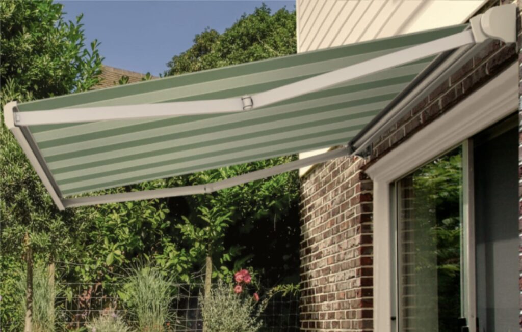 Base Lite retractable awning with white folding arms and green striped fabric