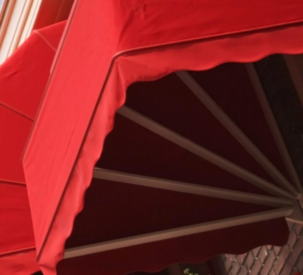 Close up image of the framework of a red commercial canopy installed by Base Direct