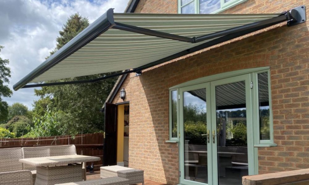 Green striped retractable awning covering double doors