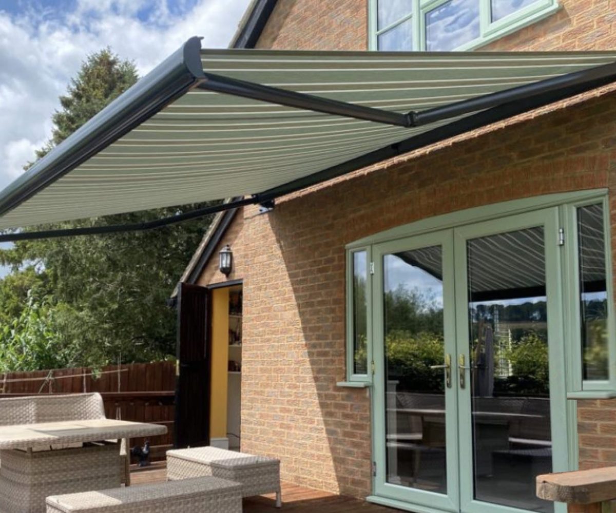 Green striped retractable awning covering double doors